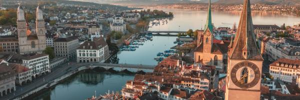Panoramic aerial view of Zurich’s old town, the Limmat River and Lake Zurich, with the Alps in the background.